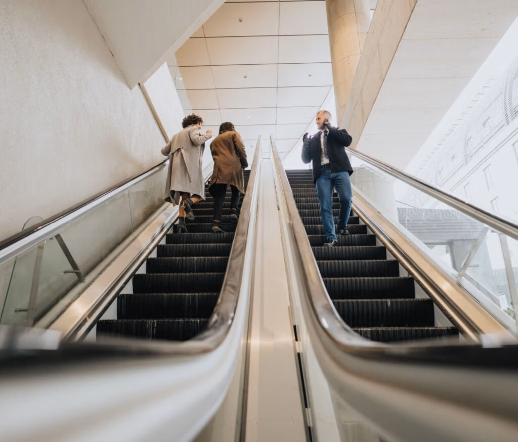 People using escalators in an office building.