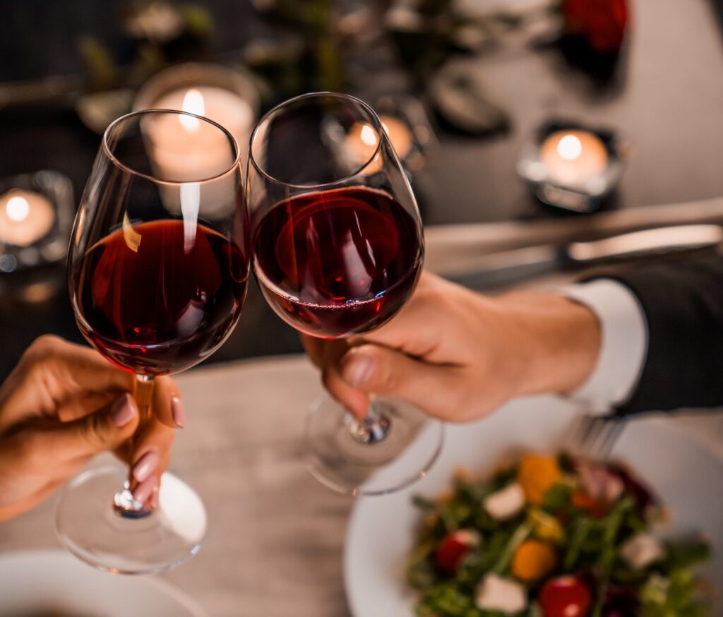 A couple toasting with wine glasses.